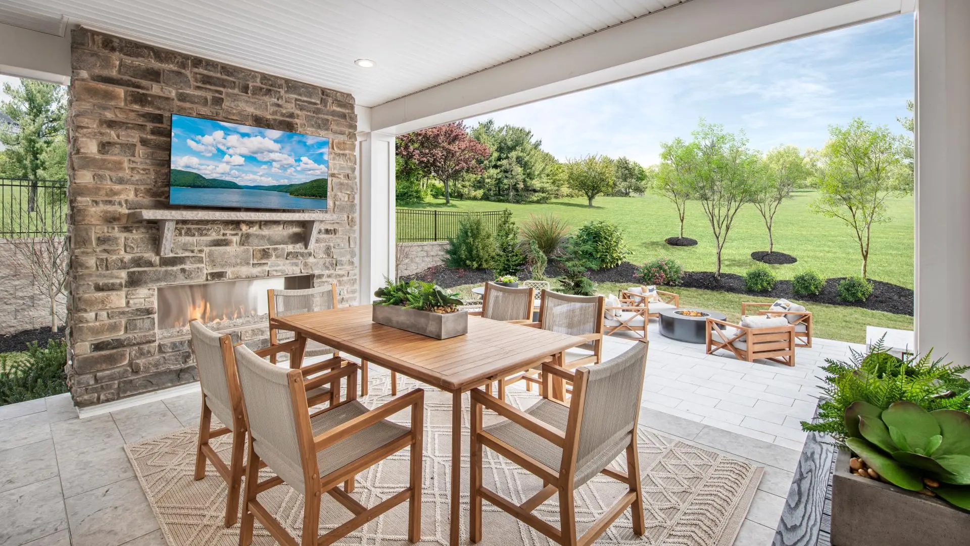 Covered outdoor living space with stone fireplace in an Orlando-area home